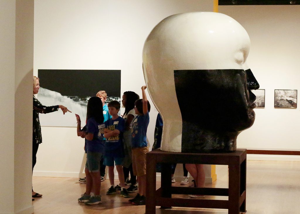 A group of grade school students in a museum gallery
