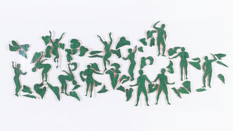 Green paper cut into leafy abstract shapes and dancing human figure shapes