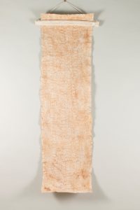 Long rectangular piece of kapa with a pebbled texture and light reddish-brown color.
