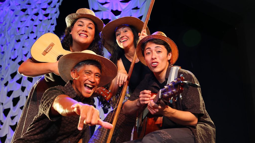 Group of four people wearing hats and smiling.
