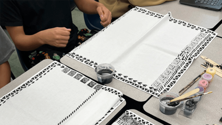 Table with bandanas being printed by students.