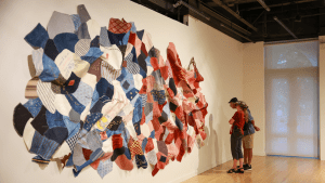 Museum vistors in gallery with large wall hanging