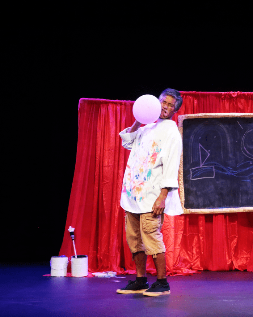 Performer pretending to be struck by a balloon