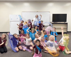 Children and teacher with lightweight scarves in different colors. They hold up, swish, and throw the scarves.