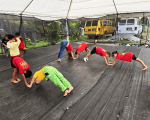Children bending their arms and legs to make m shapes. Children are working in pairs.